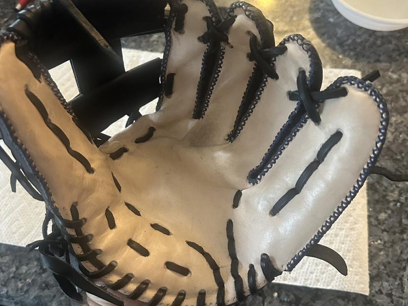 A baseball glove being shaped by hand during a game-ready break-in