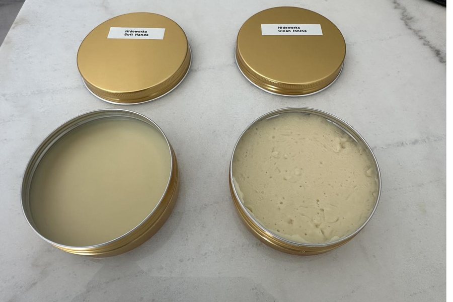 Tins of Hideworks Clean Inning glove cleaner and Soft Hands glove conditioner